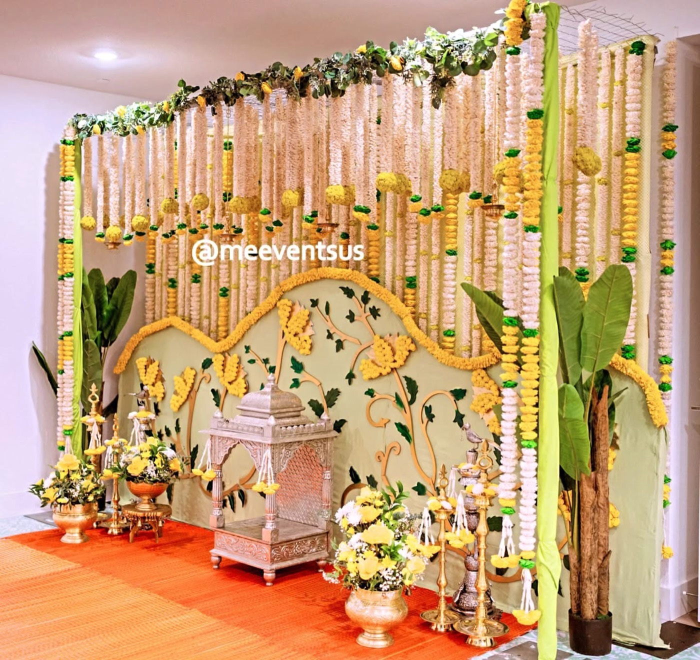 Floral mandap with carved backdrop and banana plants