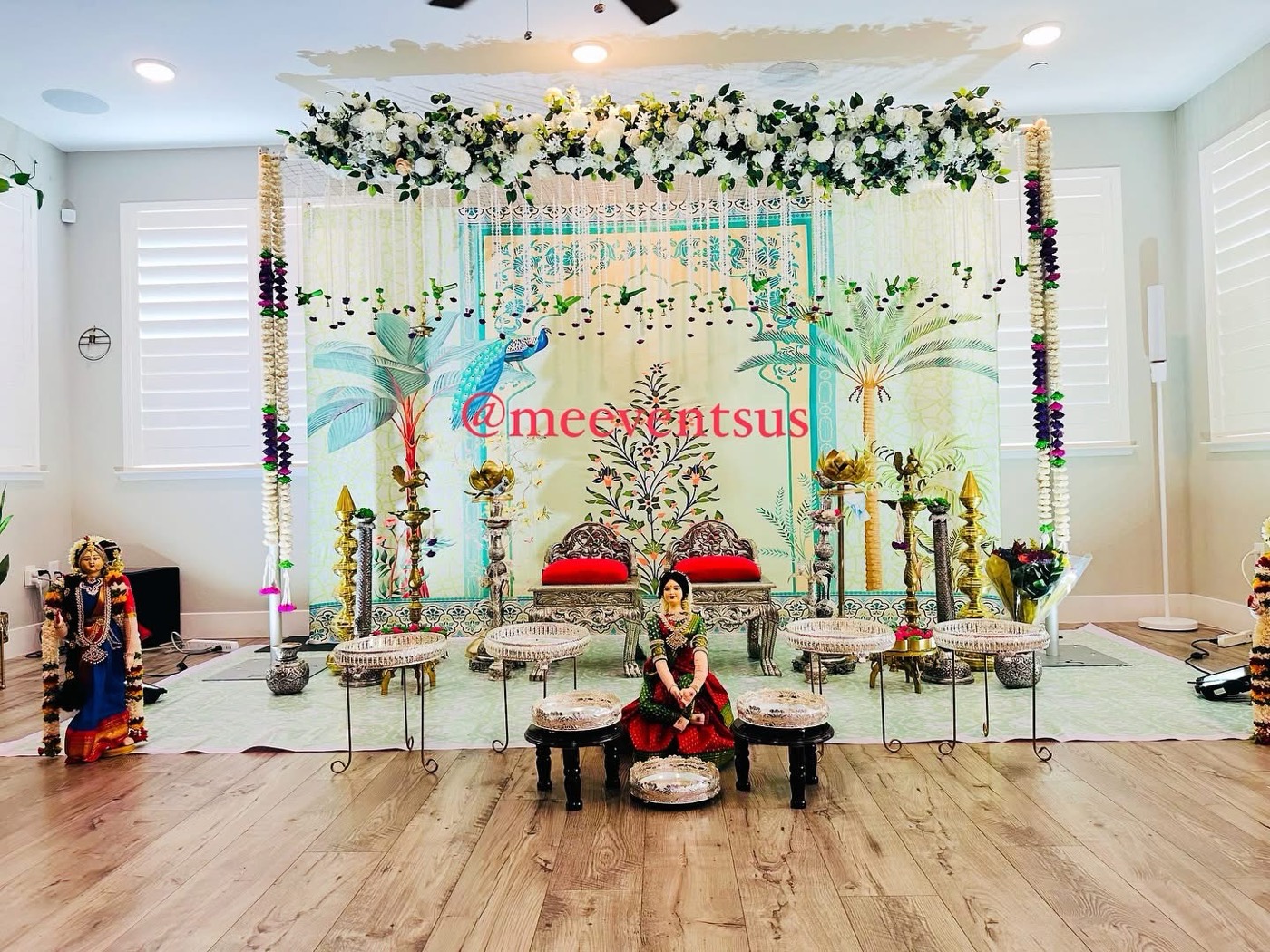 Home mandap with peacock backdrop and silver seating